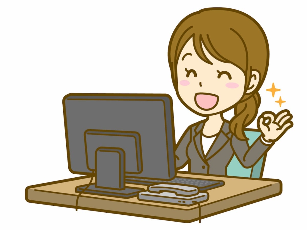 パソコンの前で笑顔な女性(会社員)