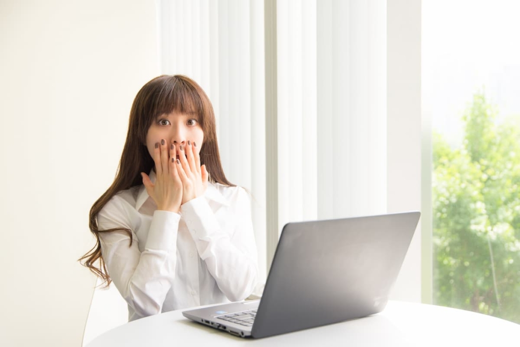 パソコンの前でビックリいている女性