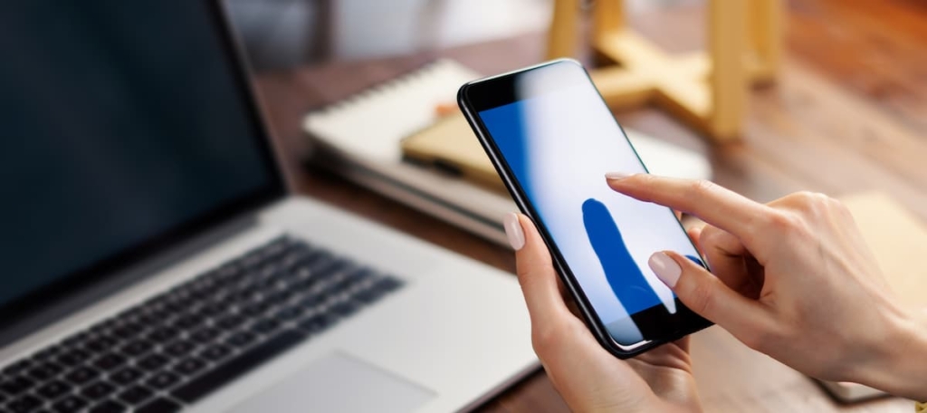 ノートパソコンとスマートフォンを利用している人