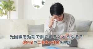 光回線を短期解約した際の違約金や工事費残債に悩む男性のイメージ